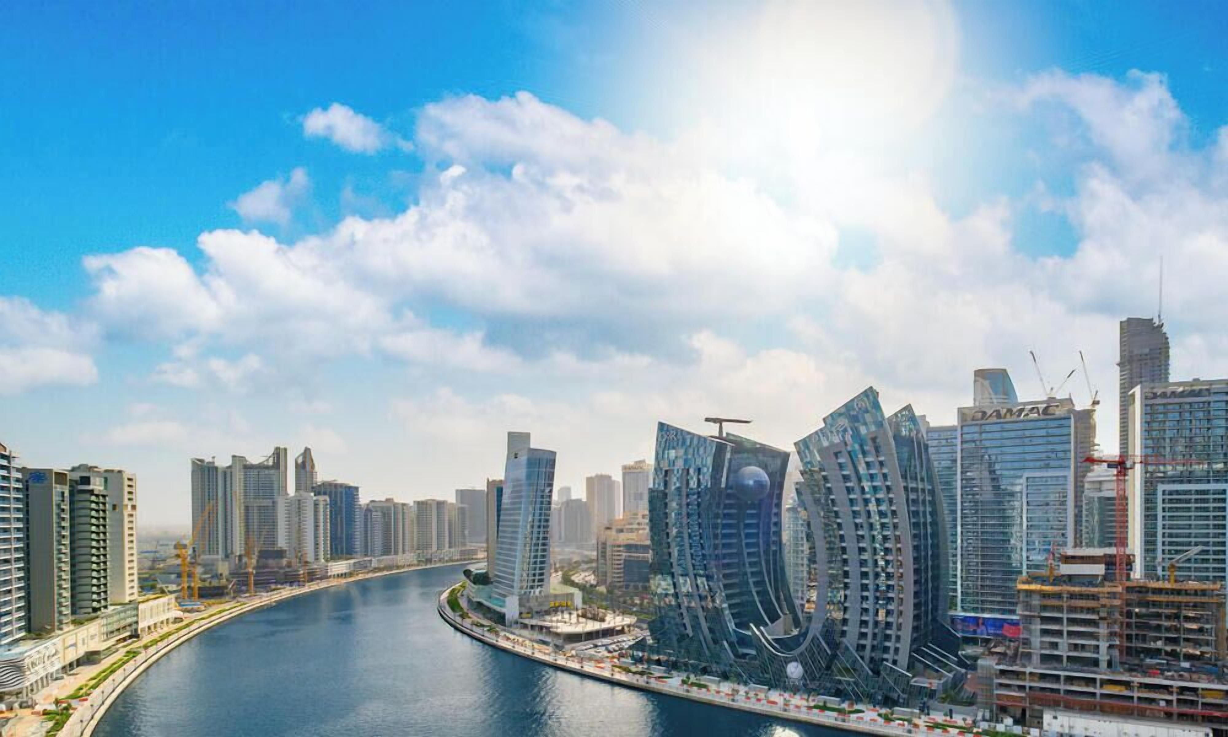 Vue sur le front de mer, avec le paysage urbain moderne de Dubaï, ses gratte-ciel et une rivière.