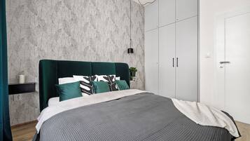 Een moderne slaapkamer met een groot bed, een kledingkast en behang met een patroon.