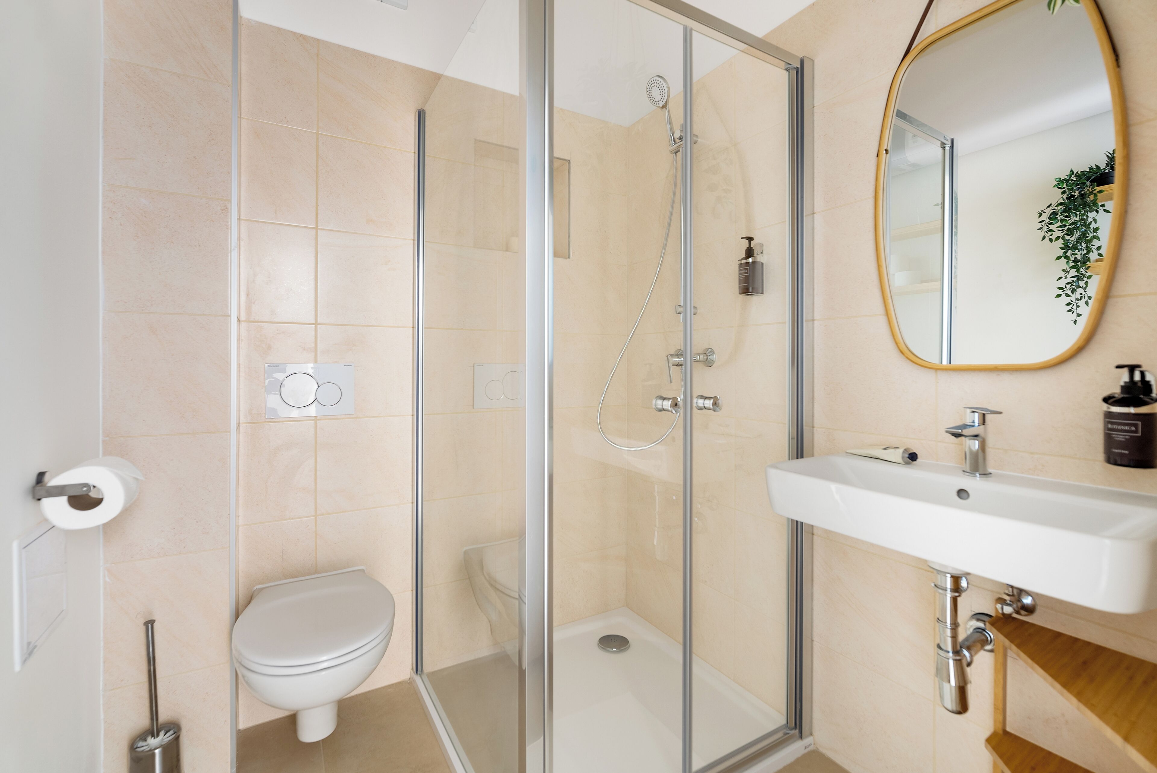 A modern bathroom with a glass-enclosed shower, a white sink, and a toilet.