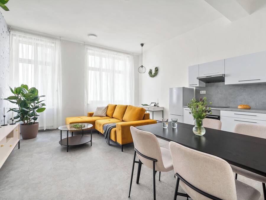 A modern living room with a sofa, coffee table, and dining area.
