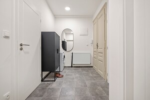 A hallway with a wardrobe, a mirror, a radiator, and a door.