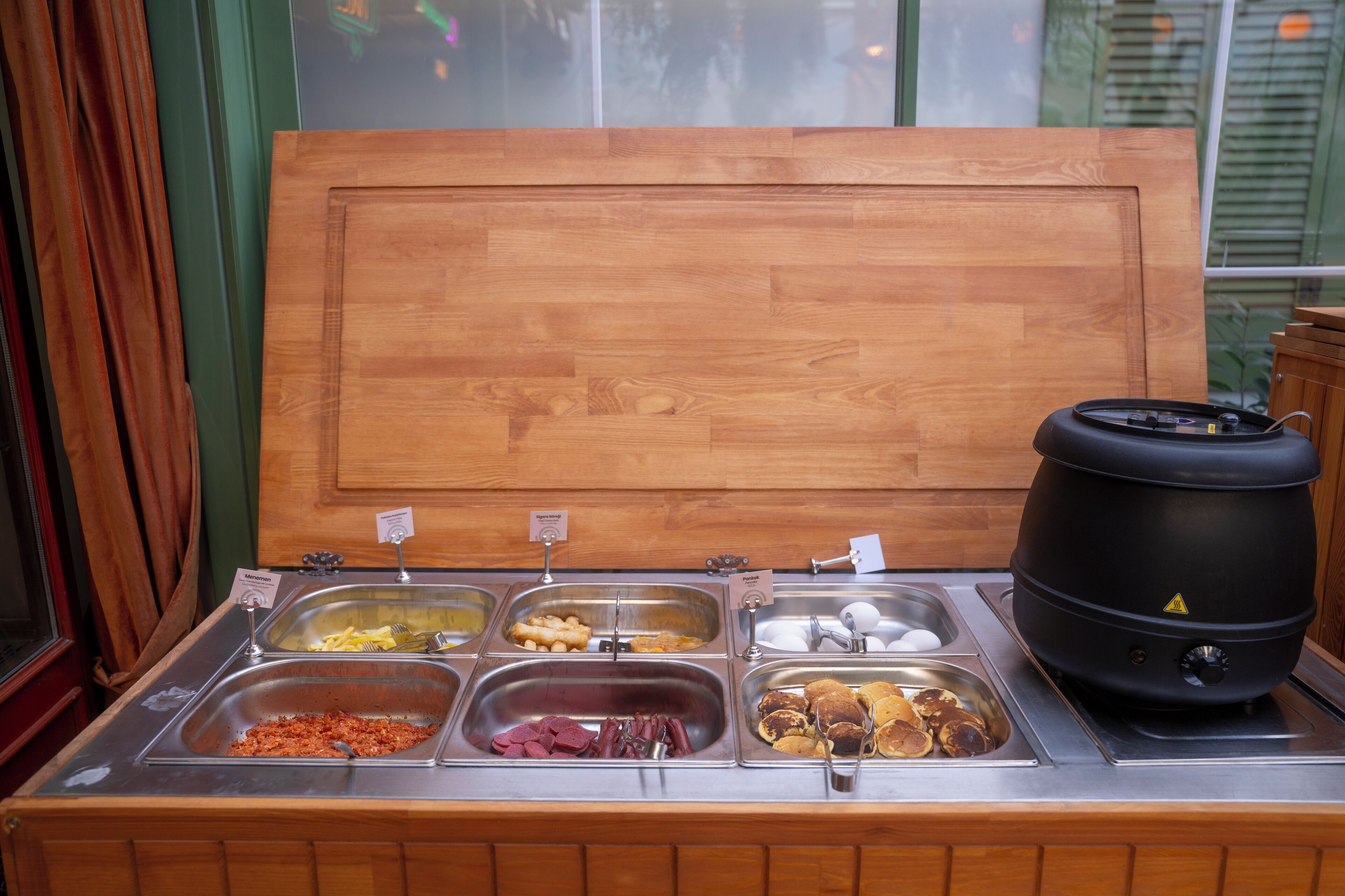 A buffet with various food items and a large black pot, likely for cooking or heating.