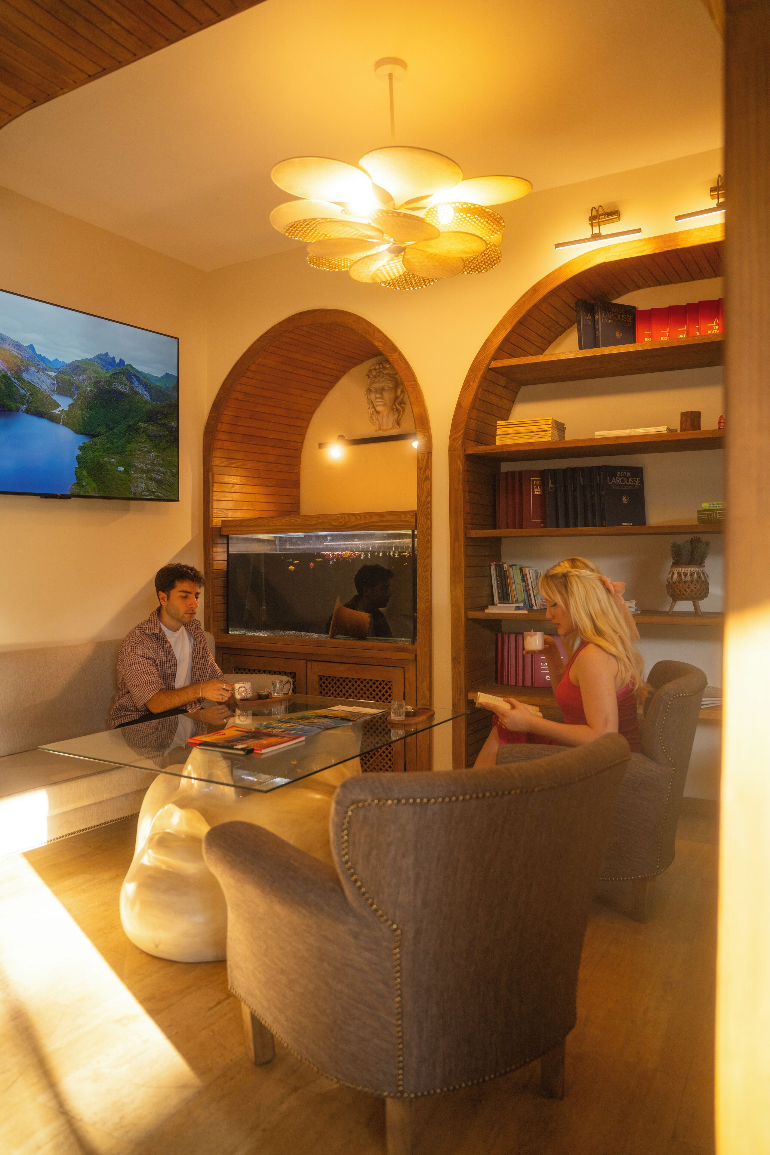 Una sala de estar con televisor, estanterías y una mesa de centro.