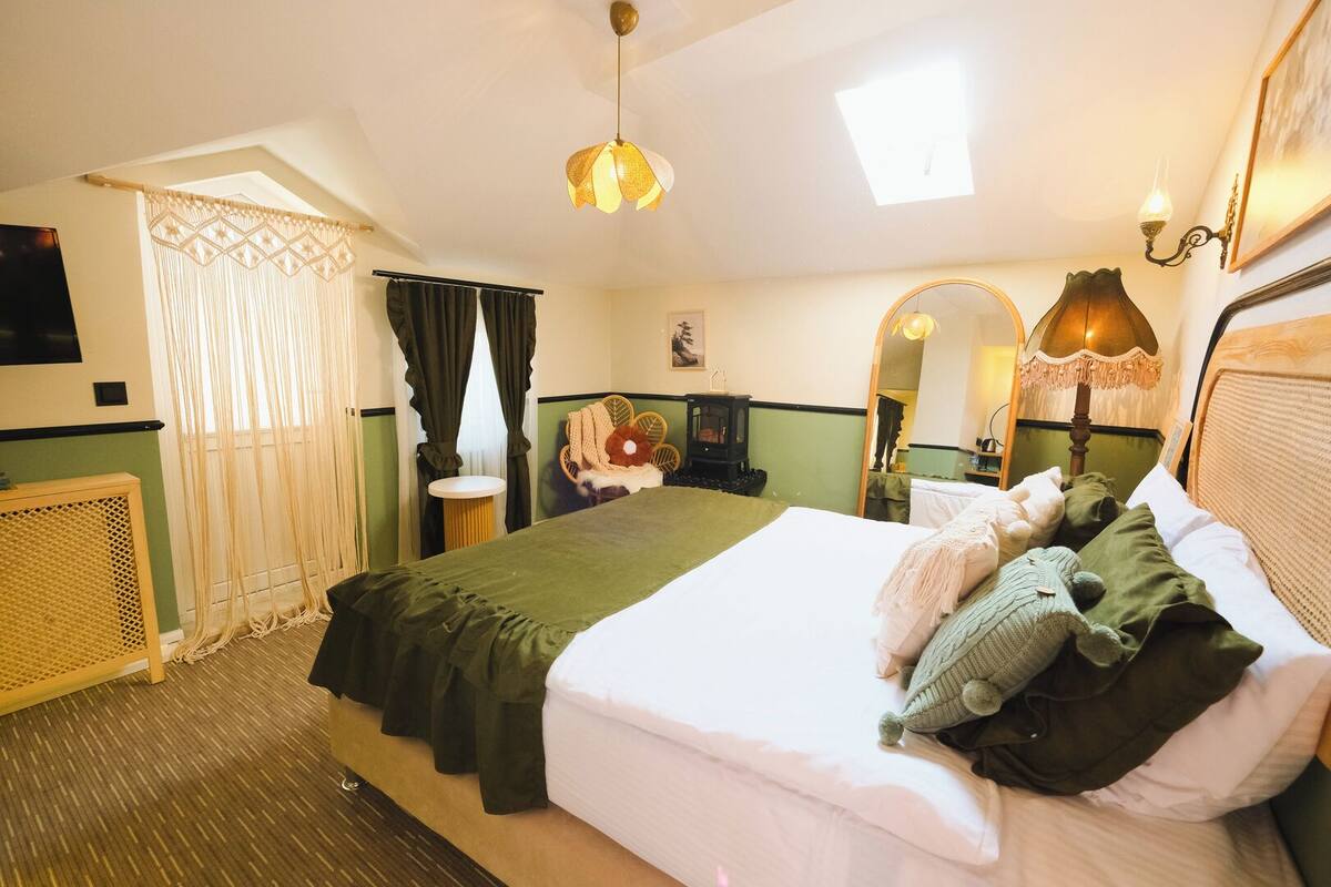 Ein Hotelzimmer mit Bett, einem kleinen Tisch, einem Stuhl, einem Heizgerät und einem Spiegel.