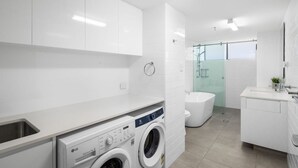 Un baño moderno con lavadora, inodoro y lavabo.