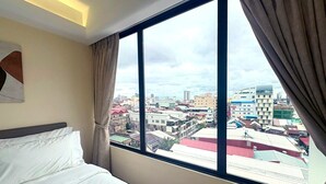 Ein Hotelzimmer mit großem Fenster und Blick auf die Stadt.