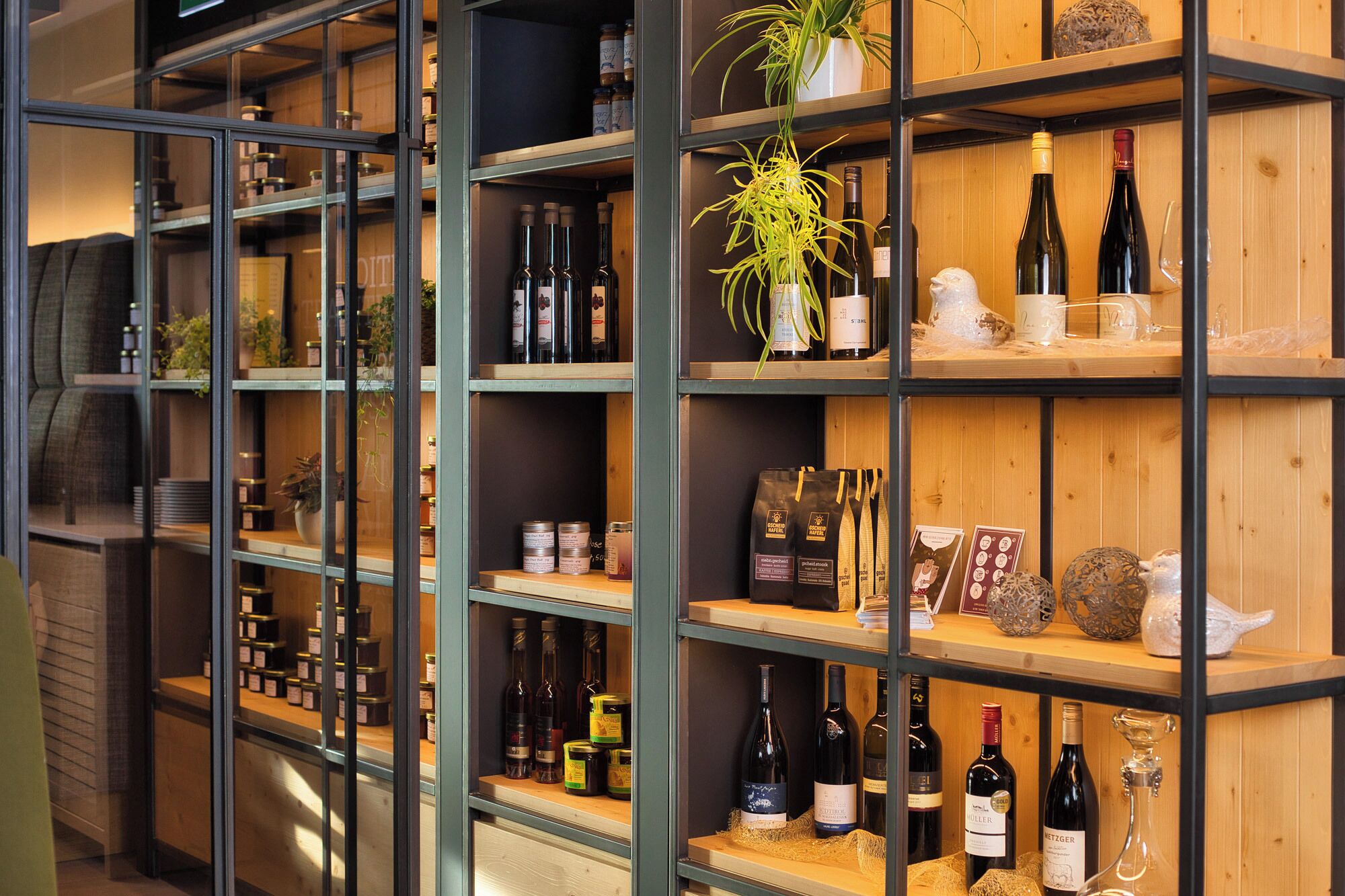 Une cave à vin dotée d’ étagères en bois et d’armoires à vitrines exposant différentes bouteilles de vin et des verres à vin.