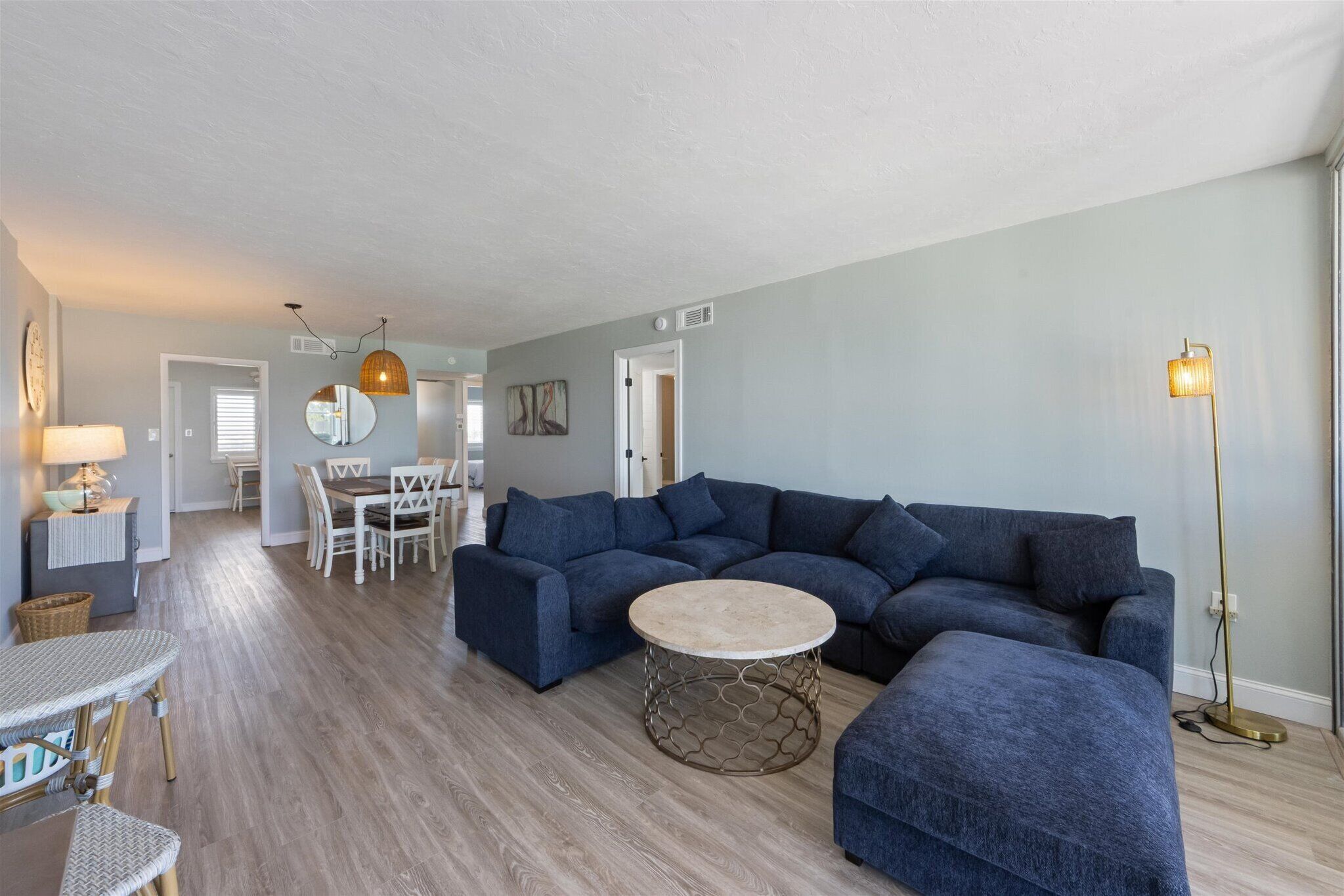 A living room with a sectional sofa, a round coffee table, and a floor lamp.