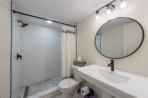 A bathroom with a shower, toilet, and sink. - Beachfront Escape at Martinique South: 2BR/2BA Condo (Holmes Beach)