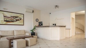 A reception area with a reception desk, a sofa, and a coffee table. - Konstantinos Hotel & Apartments I (Nidri)