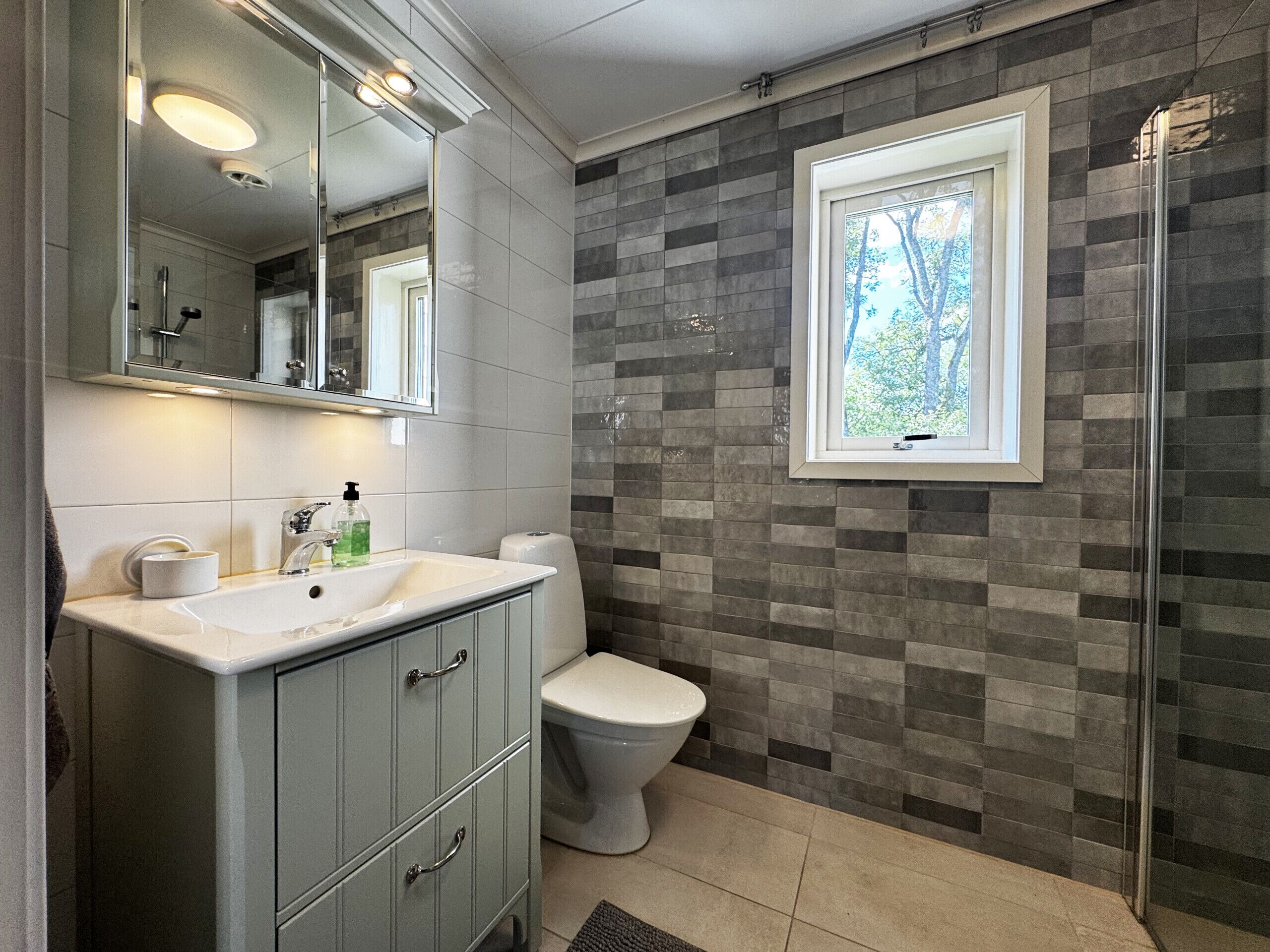 A bathroom with a white sink, a toilet, and a shower.