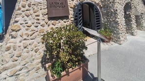 A building with a stone facade and a sign reading "LA TORRE SPAGNOLA MAURIZIO". - La Torre del Nostromo (Salerno)