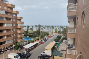 Een hotel met meerdere verdiepingen, balkons, een parkeerplaats en een zwembad.