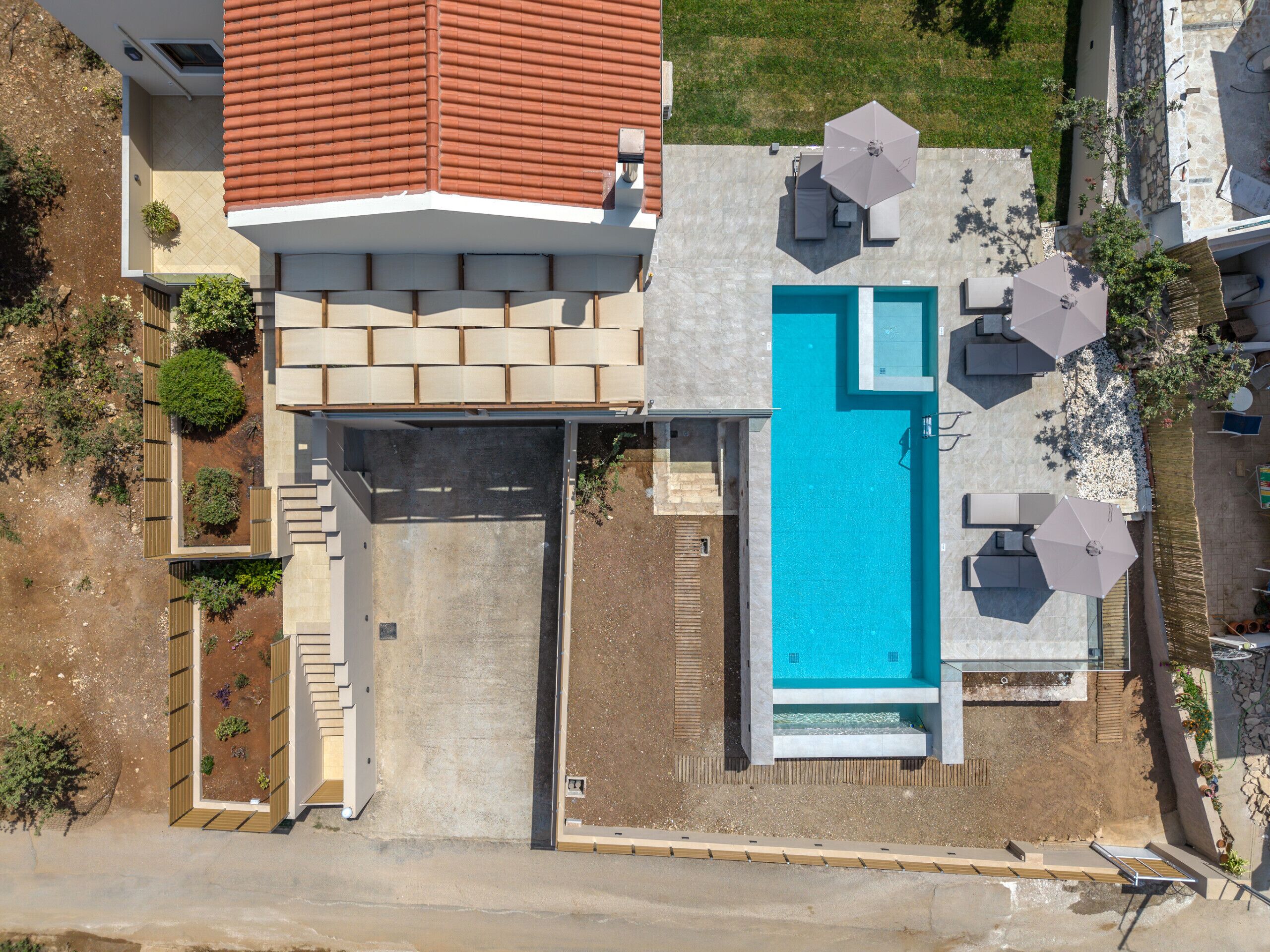 Una casa moderna con piscina, mobiliario exterior y jardín.