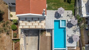 A modern house with a swimming pool, outdoor seating, and a garden. - Athos Rural Villa (Rethymno)