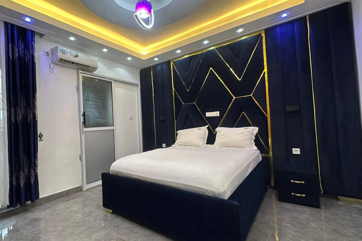 Une chambre moderne équipée d’un lit, d’une armoire et d’un système de climatisation intégré.