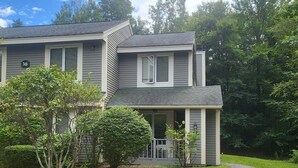 A two-story house with a grey exterior and a covered porch. - Multi-level, open concept, AC, wooded view, deck, swim club. F1602 by LRS (Lincoln)