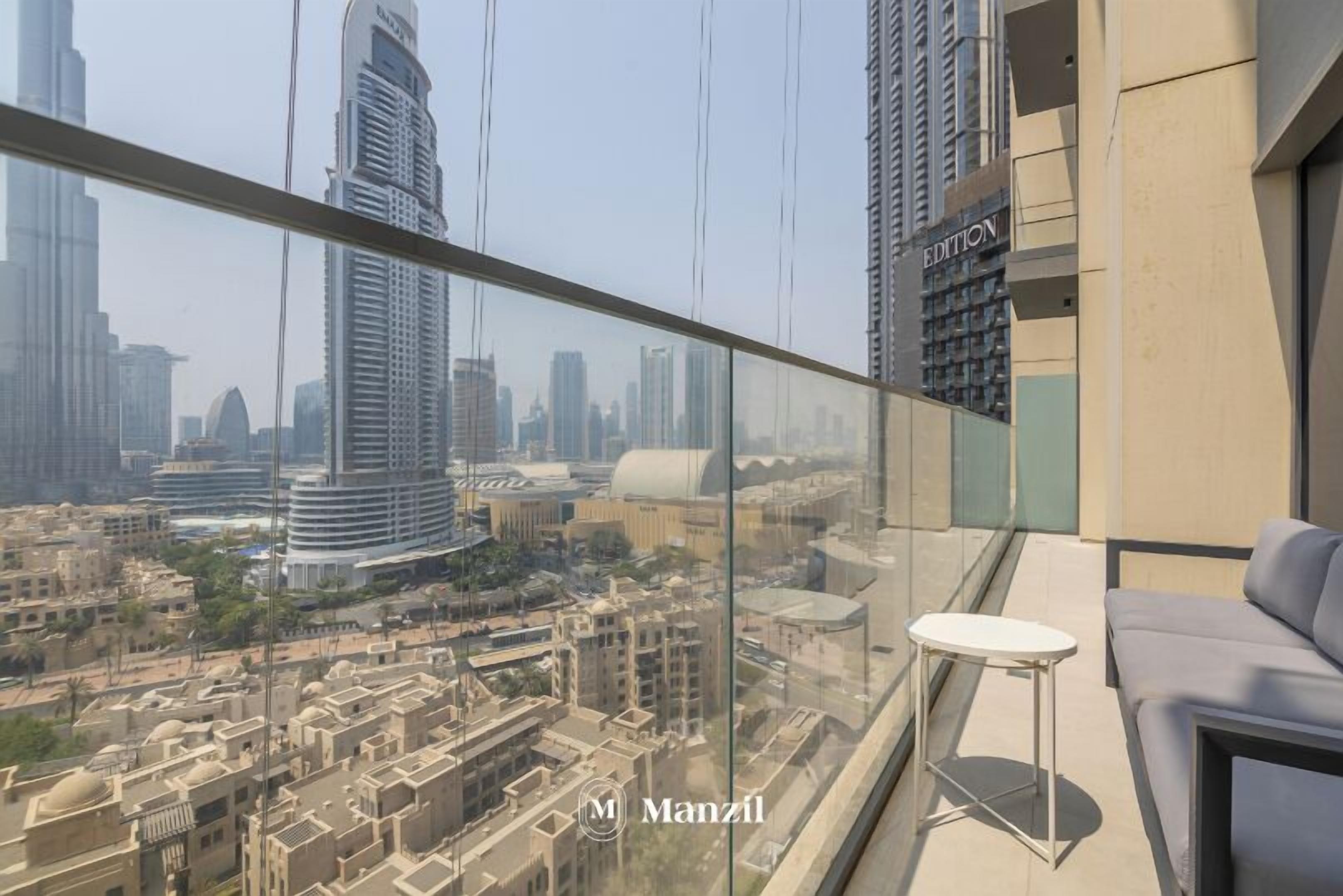Een hoog gebouw met een glazen balkon met uitzicht op een stadsbeeld.