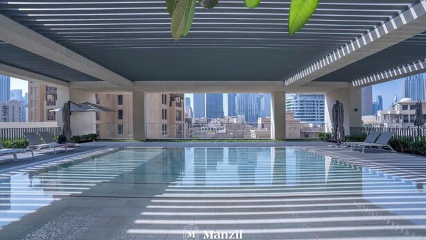 Une piscine moderne située sur le toit, offrant une vue dégagée sur les gratte-ciel de la ville.