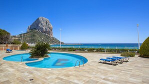 A pool area with a view of the sea and a rocky cliff. - RUBINO 9A - Apartment with sea views and communal swimming pool (Calpe)