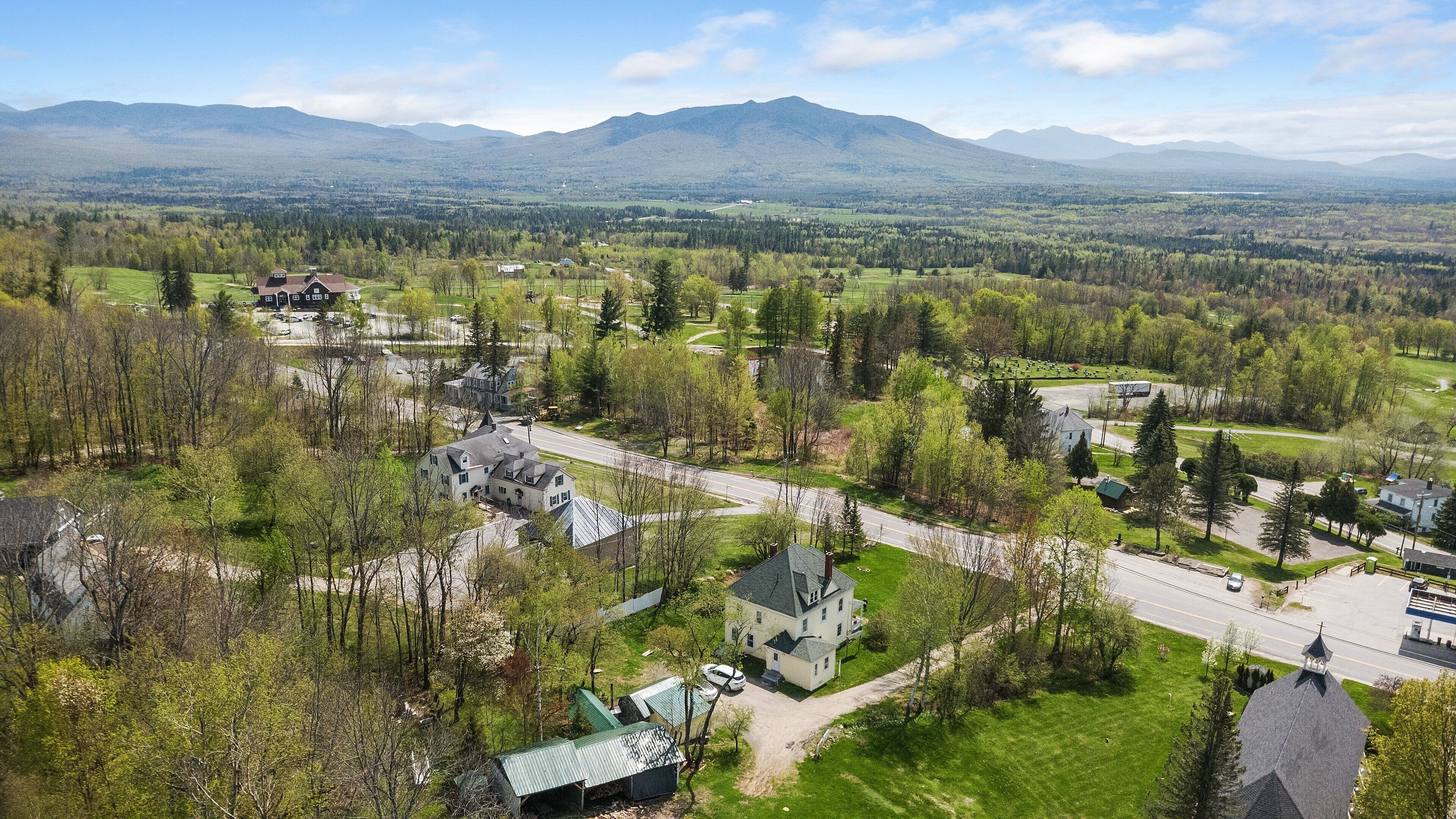 A residential area with houses, roads, and a mountainous backdrop.