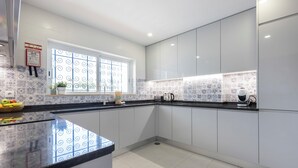 A modern kitchen with white cabinets, a black countertop, and patterned backsplash tiles. - Apartment do Ramses with oceanviews (Luz)