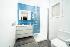 A modern bathroom with a white vanity, a glass shower enclosure, and a toilet. - Scenic Mountain View Escape w/ Pool & Tennis (els Castellons)