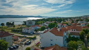 A coastal residential area with houses, a road, and a body of water.