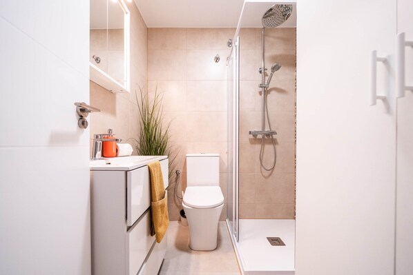 Un baño moderno con inodoro, ducha y lavamanos.