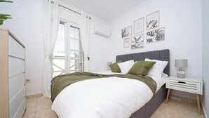 A bedroom with a bed, a nightstand, a lamp, and wall art.