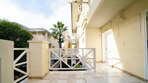 A gated entrance to a building with a tiled floor and a white gate.