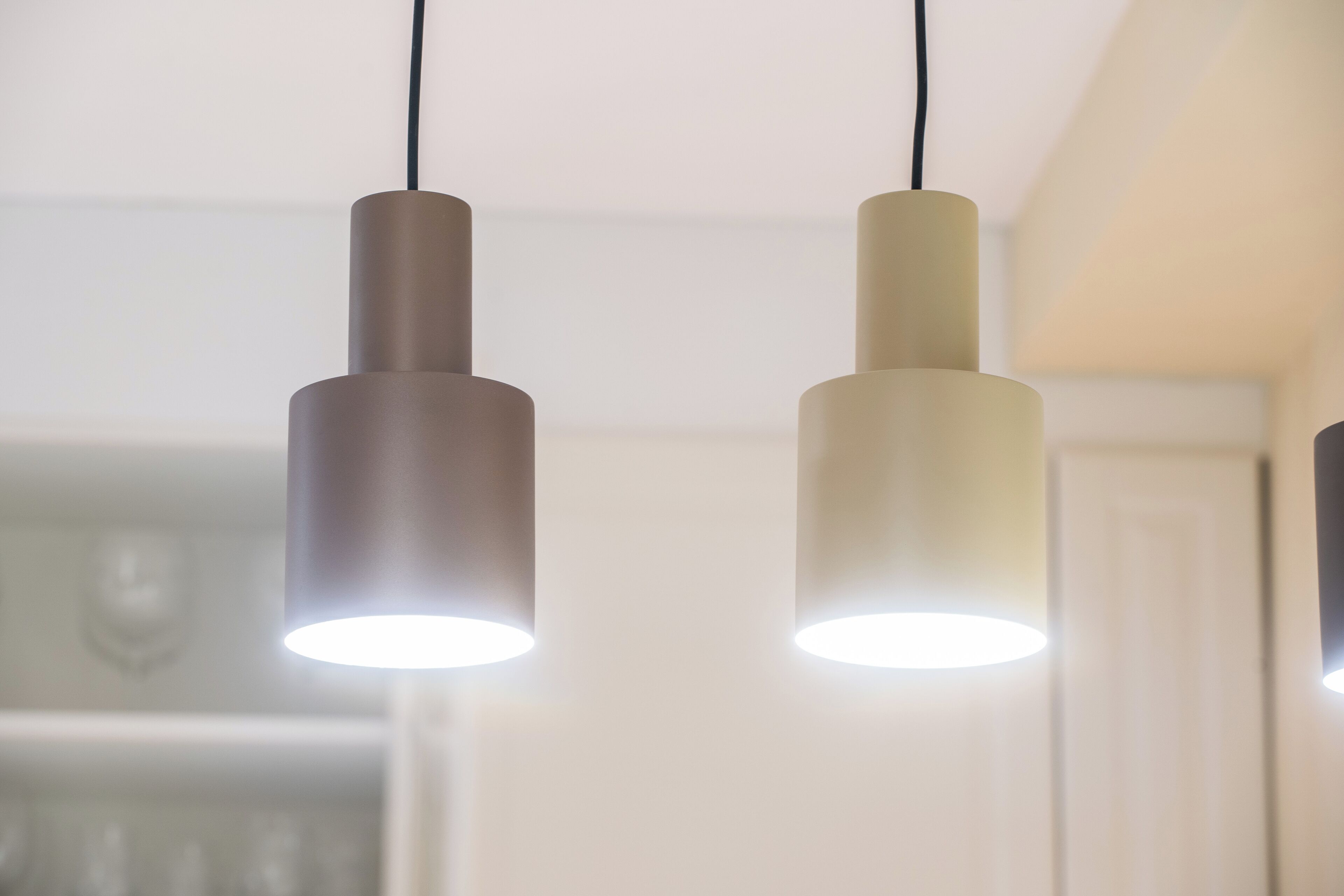 Una cocina moderna con luces colgantes y un armario blanco.