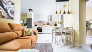 Un salon moderne avec un canapé et un coin repas comprenant une table et des chaises.