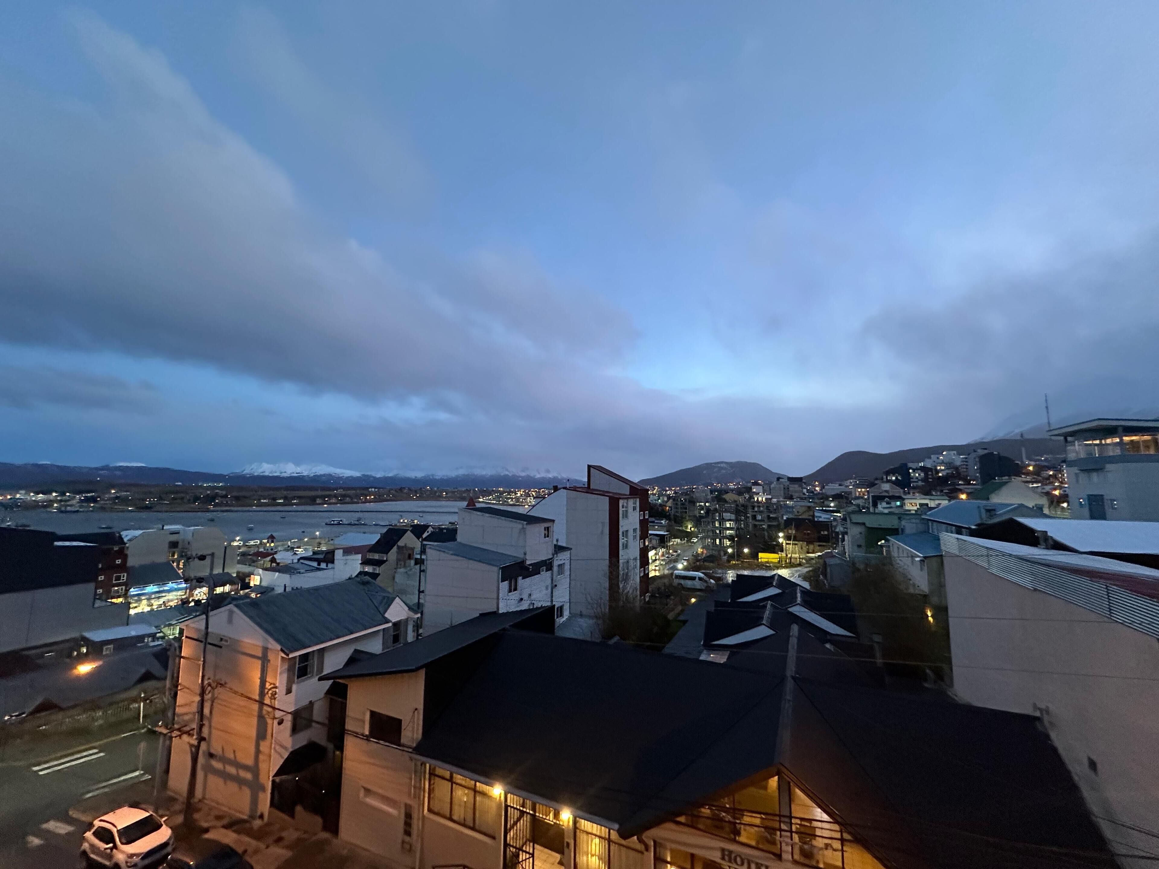 A hotel with a view of a cityscape and mountains in the background.