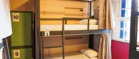 A bunk bed room with three levels, numbered 2, 9, and 10, and a window with curtains.