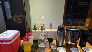 Une petite cuisine équipée d’un réfrigérateur, d’une machine à café et de divers produits alimentaires.