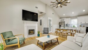 A spacious living room with a fireplace, a dining area, and a kitchen with white cabinets. - Walk to Beltline: Wfh-friendly Hub w/ Yard! (Atlanta)