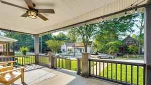 A covered outdoor area with a wooden deck, a ceiling fan, and a view of a street with houses and cars. - Walk to Beltline: Wfh-friendly Hub w/ Yard! (Atlanta)
