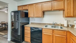A kitchen with wooden cabinets, a stainless steel refrigerator, a dishwasher, and a granite countertop. - 3 Mi to Talking Stick: Condo w/ Community Perks! (Scottsdale)
