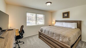 A bedroom with a wooden bed, a desk with a chair, a window with blinds, and a framed picture on the wall. - 3 Mi to Talking Stick: Condo w/ Community Perks! (Scottsdale)