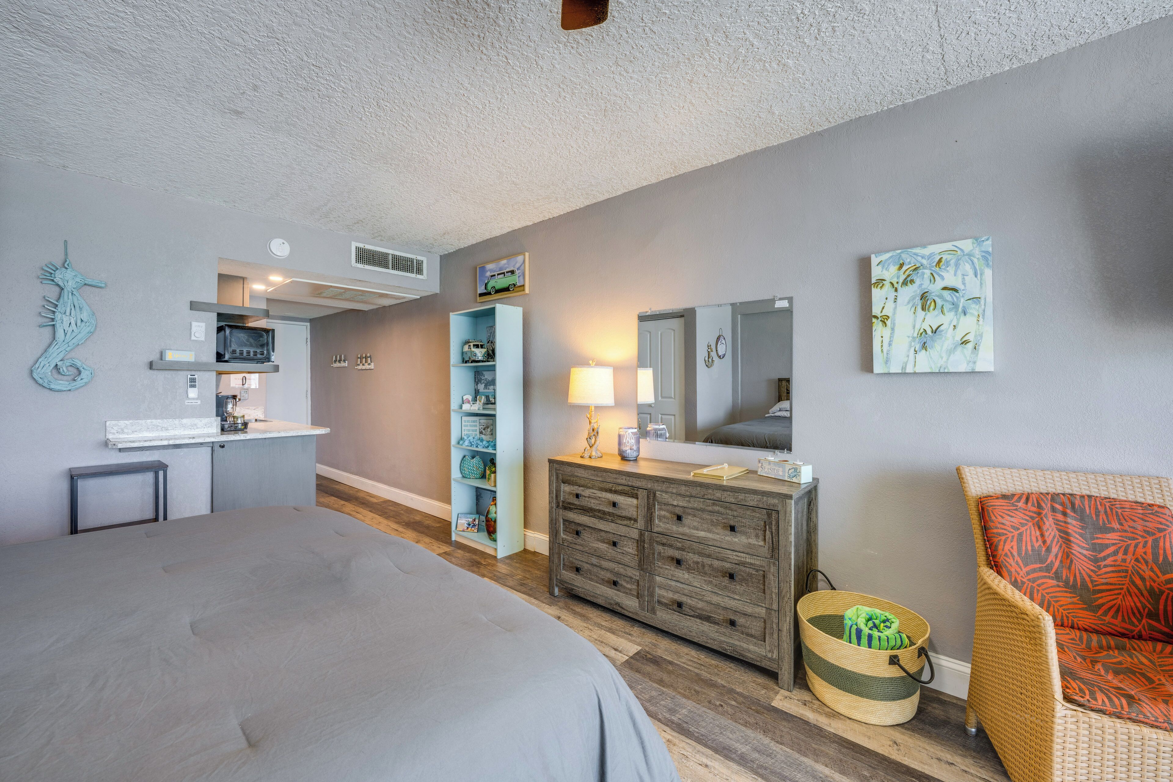 A bedroom with a bed, dresser, and a chair.