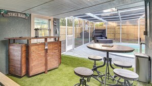 A backyard with a wooden tiki bar, a pool, and a covered patio area. - 3 Mi to Apollo Beach Preserve: Family Retreat! (Apollo Beach)