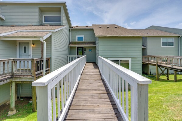 A wooden walkway connecting multiple buildings with a green exterior. - Boat & Fish: Gem w/ Water Views on Lake Livingston (Livingston)