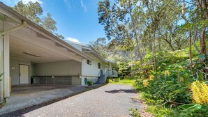A two-story building with a covered porch and a garage. - Private Hot Tub & Deck: Tranquil Volcano Hideaway! (Volcano)
