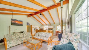 A spacious living room with a high ceiling and exposed beams, a dining area, and a kitchen. - Private Hot Tub & Deck: Tranquil Volcano Hideaway! (Volcano)
