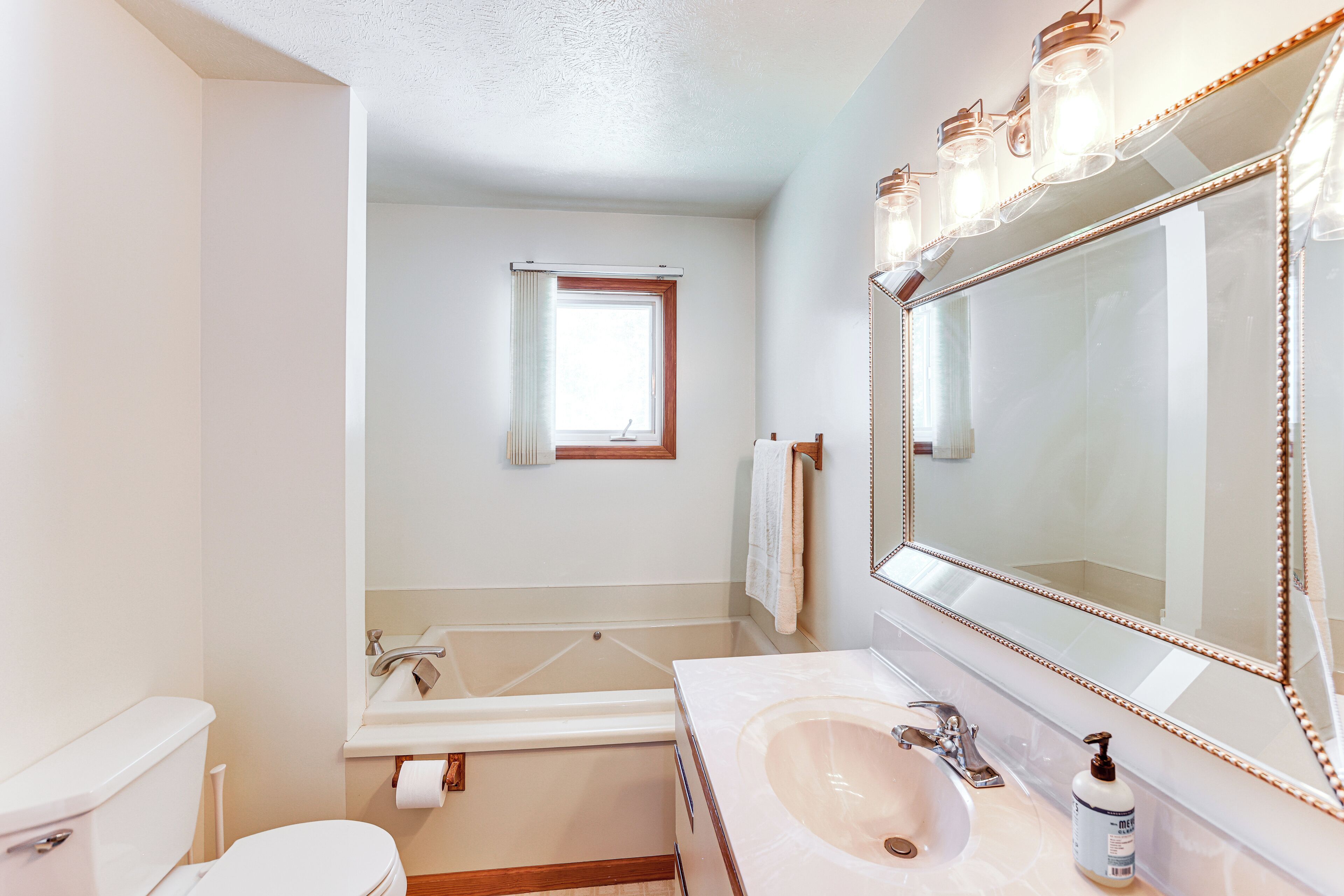 A bathroom with a toilet, sink, and bathtub.
