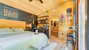 Une chambre confortable avec un grand lit, un bureau et une kitchenette.