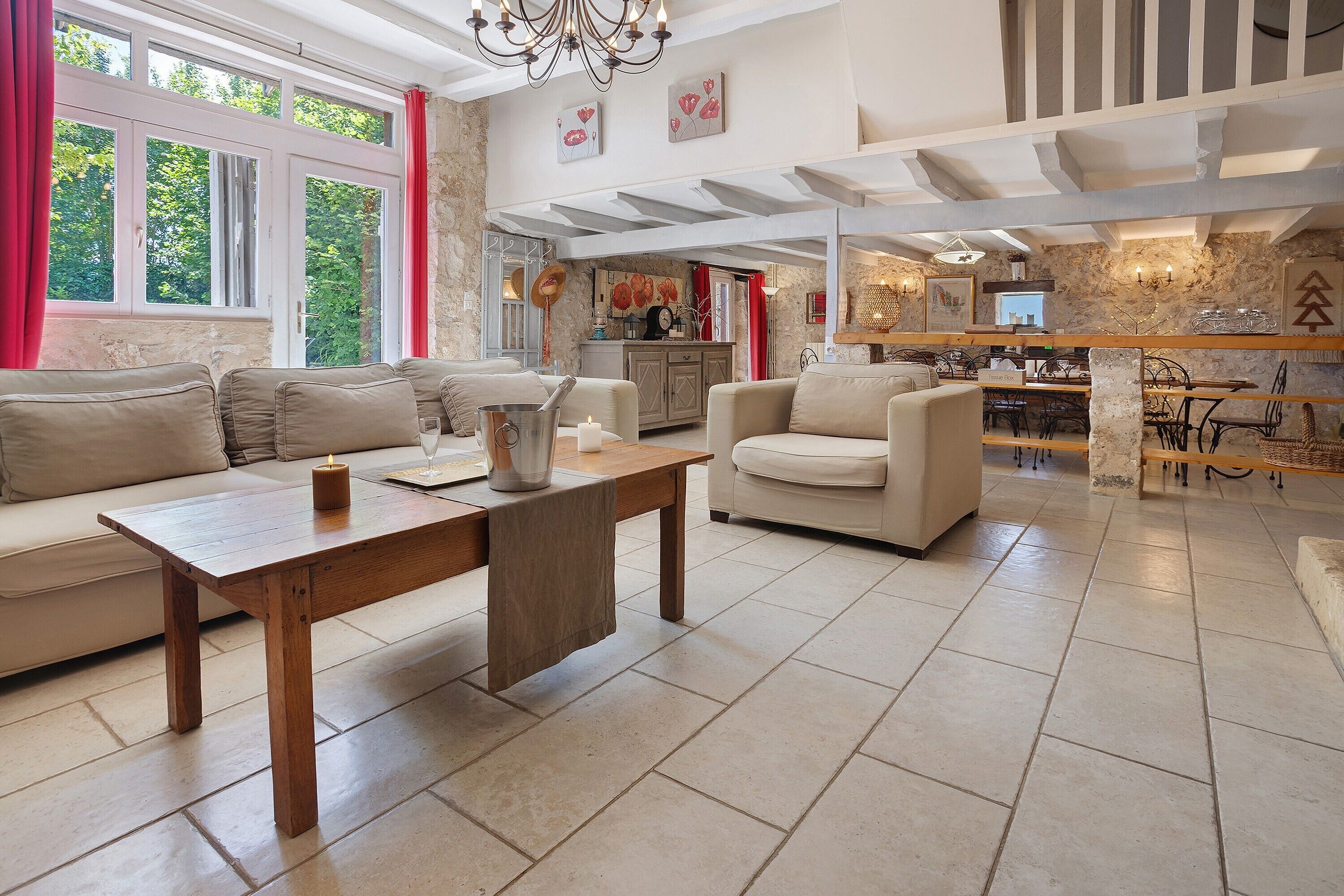 Een ruime woonkamer met een houten salontafel, beige banken en een keuken op de achtergrond.