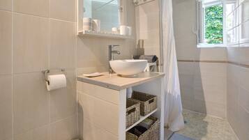 Ein Badezimmer mit Waschbecken, Spiegel, Toilette und Fenster.