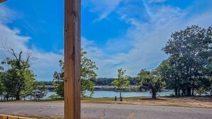 Une terrasse en bois offrant une vue sur un lac et des arbres.